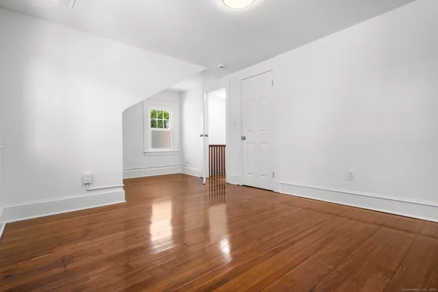 a view of a room with wooden floor and window