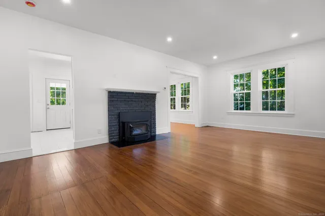 a view of a livingroom with wooden floor and a fireplace