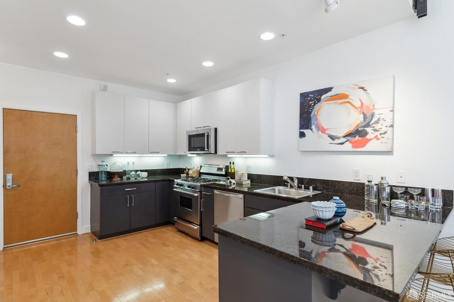 1 Rausch Street, Unit G San Francisco, CA 94103 - Photo 14 of 49 a kitchen with stainless steel appliances granite countertop a stove and a refrigerator