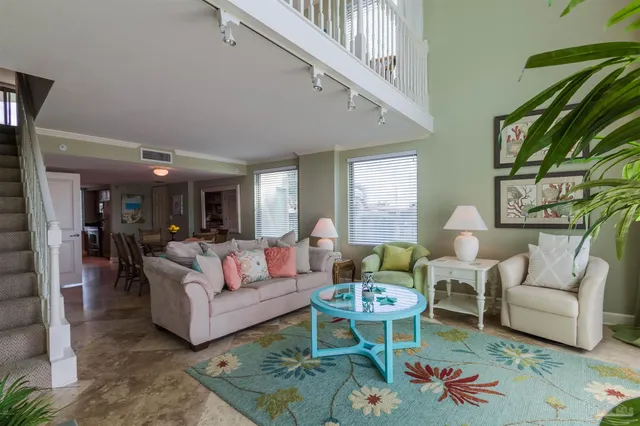 a living room with furniture kitchen view and a large window
