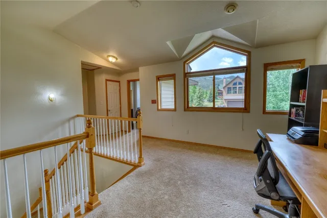 a view of a workspace with furniture and a window