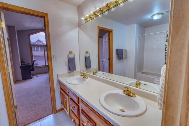 a en suite bathroom with a double vanity sink and a mirror