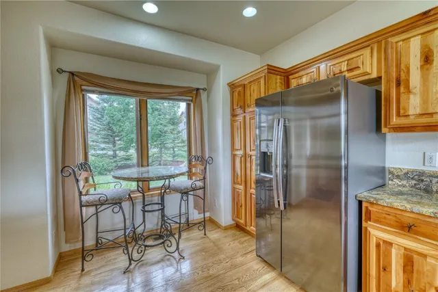a dining room with stainless steel appliances granite countertop furniture and a window
