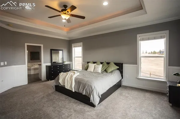 a spacious bedroom with a bed and a chandelier