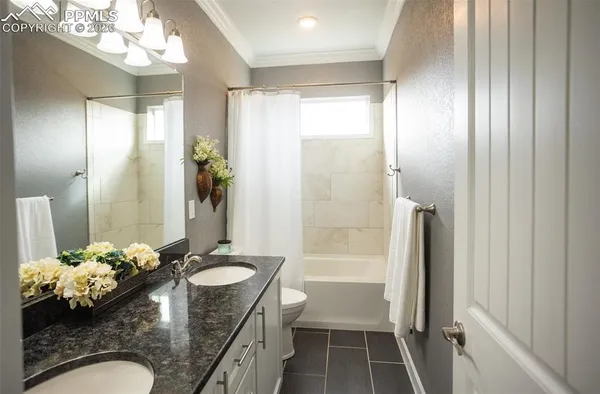 a bathroom with a granite countertop sink a toilet and shower