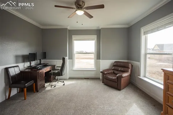 a view of a workspace with furniture and a window