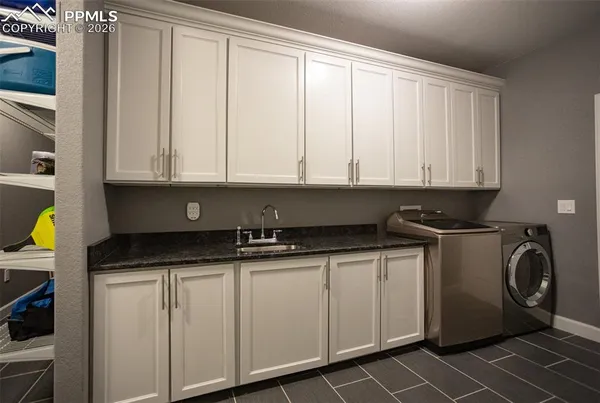 a kitchen with granite countertop a sink a stove and cabinets