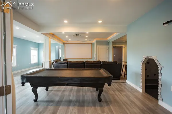 a room with pool table windows and wooden floor