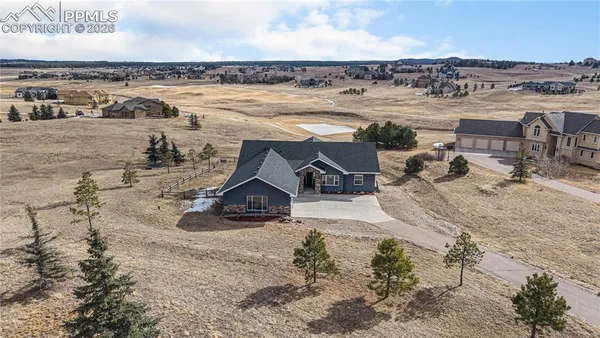 an aerial view of a house with a yard and ocean view