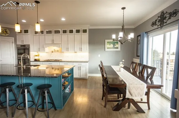 a kitchen with kitchen island granite countertop a table chairs stove and refrigerator