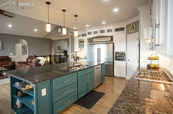 a kitchen with a refrigerator a sink and wooden floor