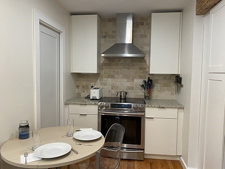 274 Main Street, Unit 5 Gloucester, MA 01930 - Photo 3 of 17 a kitchen with a stove a sink and cabinets