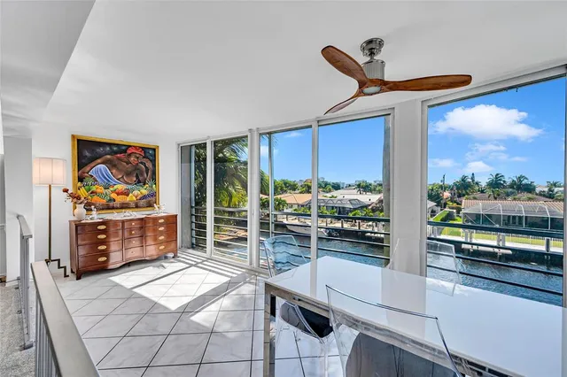 a living room with furniture a flat screen tv and floor to ceiling window
