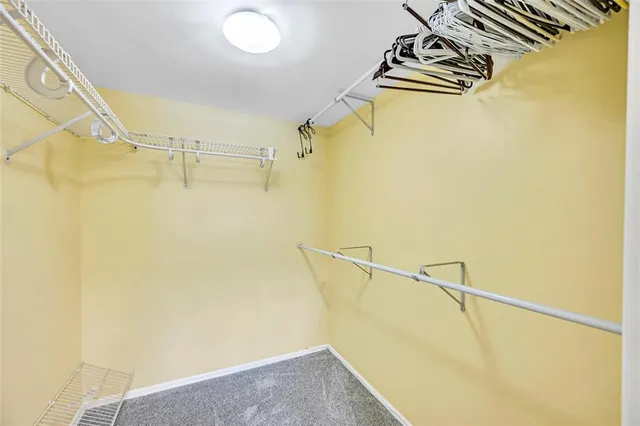 a bedroom with a bed and a lamp on dresser