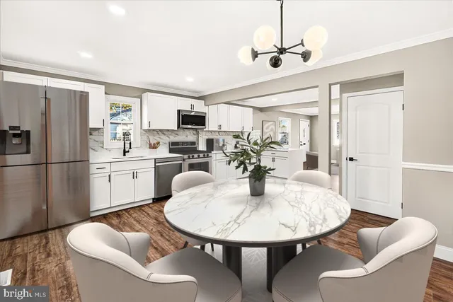 a kitchen with sink refrigerator dining table and chairs