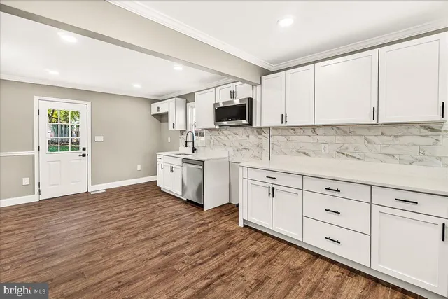a kitchen with white cabinets and sink