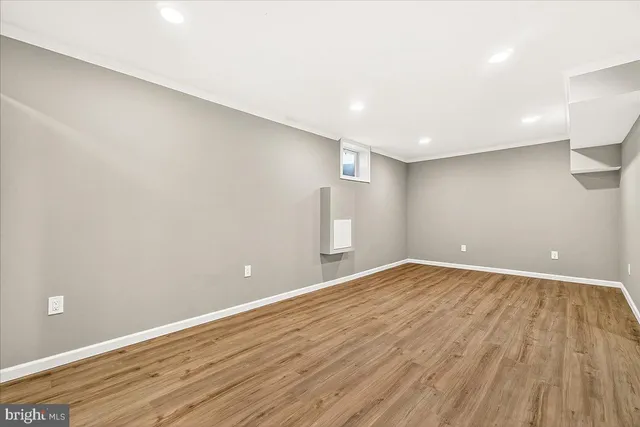 a view of an empty room with wooden floor