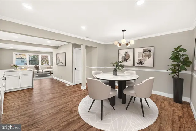 a dining room with wooden floor a chandelier a wooden table and chairs