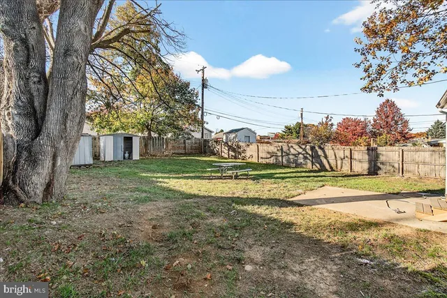 a view of a house with backyard and trees