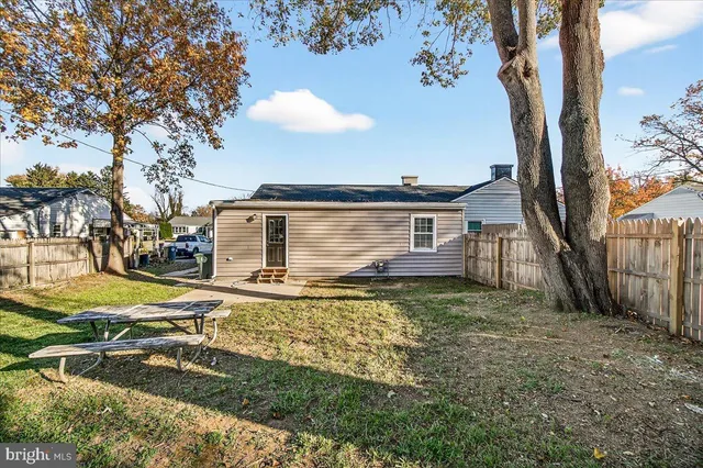 a view of a house with backyard and trees