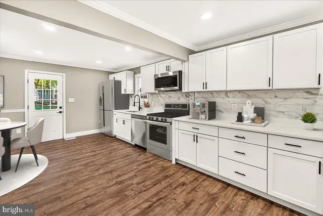 a kitchen with white cabinets stainless steel appliances and sink
