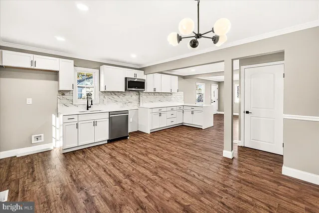 a large kitchen with cabinets a sink and stainless steel appliances