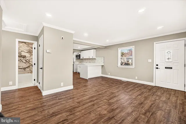a view of a kitchen with wooden floor and a window