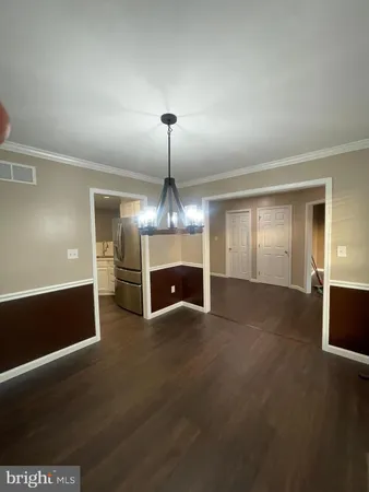 a view of an empty room with wooden floor fireplace and a window