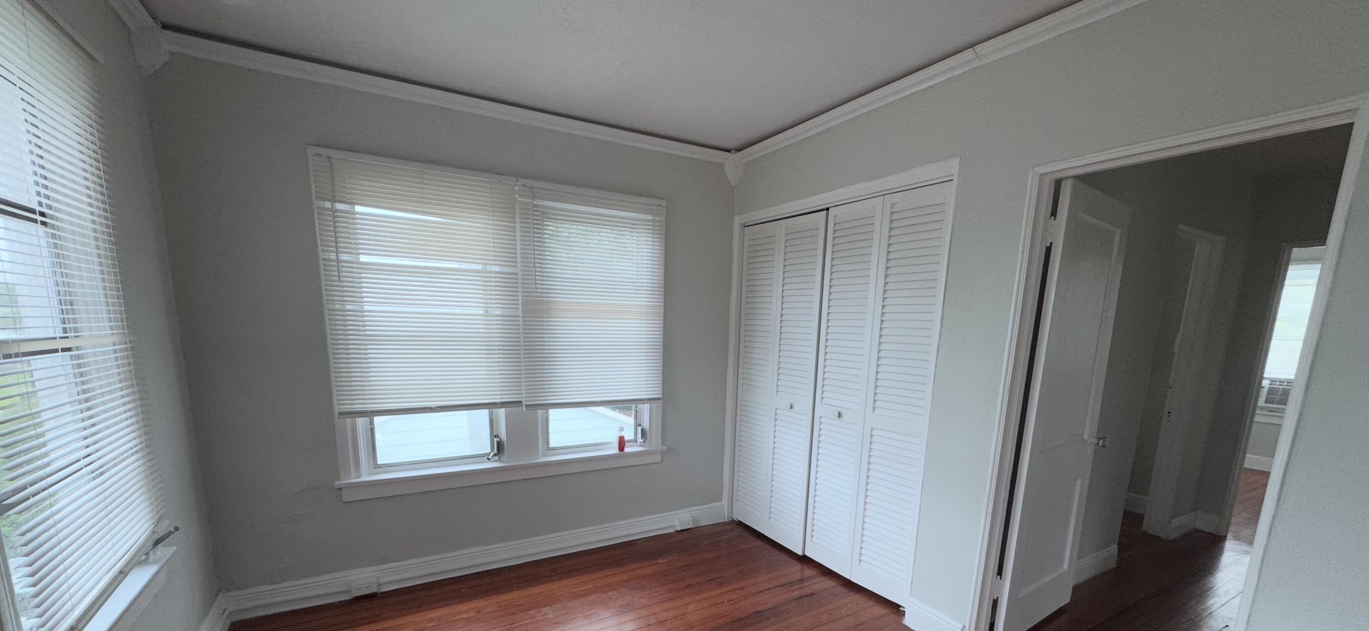 736 Omar Road, Unit 4 West Palm Beach, FL 33405 - Photo 12 of 17 an empty room with wooden floor and windows