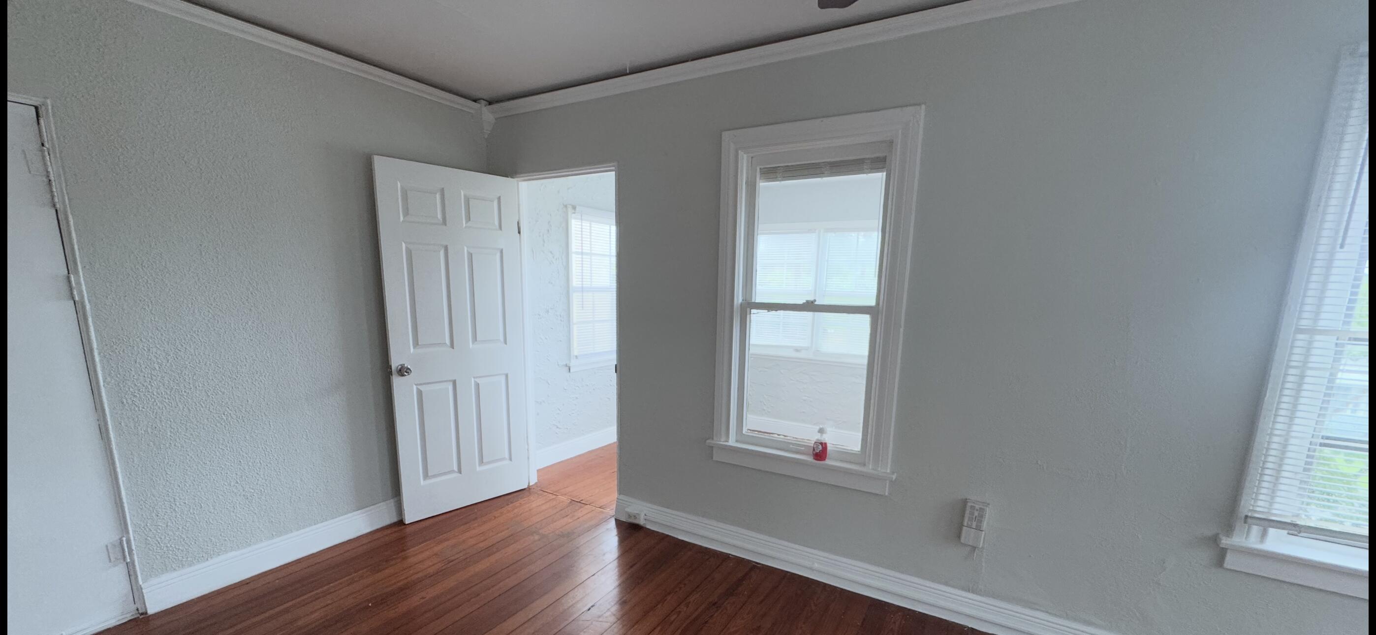 736 Omar Road, Unit 4 West Palm Beach, FL 33405 - Photo 5 of 17 an empty room with wooden floor and windows