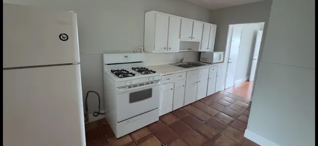 a kitchen with stainless steel appliances a refrigerator sink and white cabinets