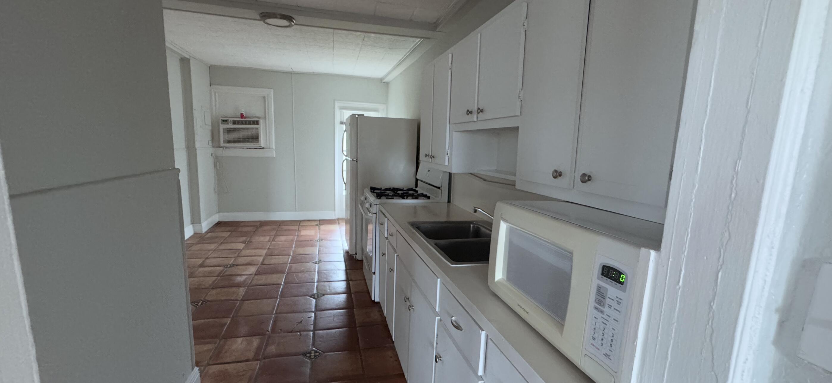 736 Omar Road, Unit 4 West Palm Beach, FL 33405 - Photo 7 of 17 a kitchen with a sink a refrigerator and cabinets