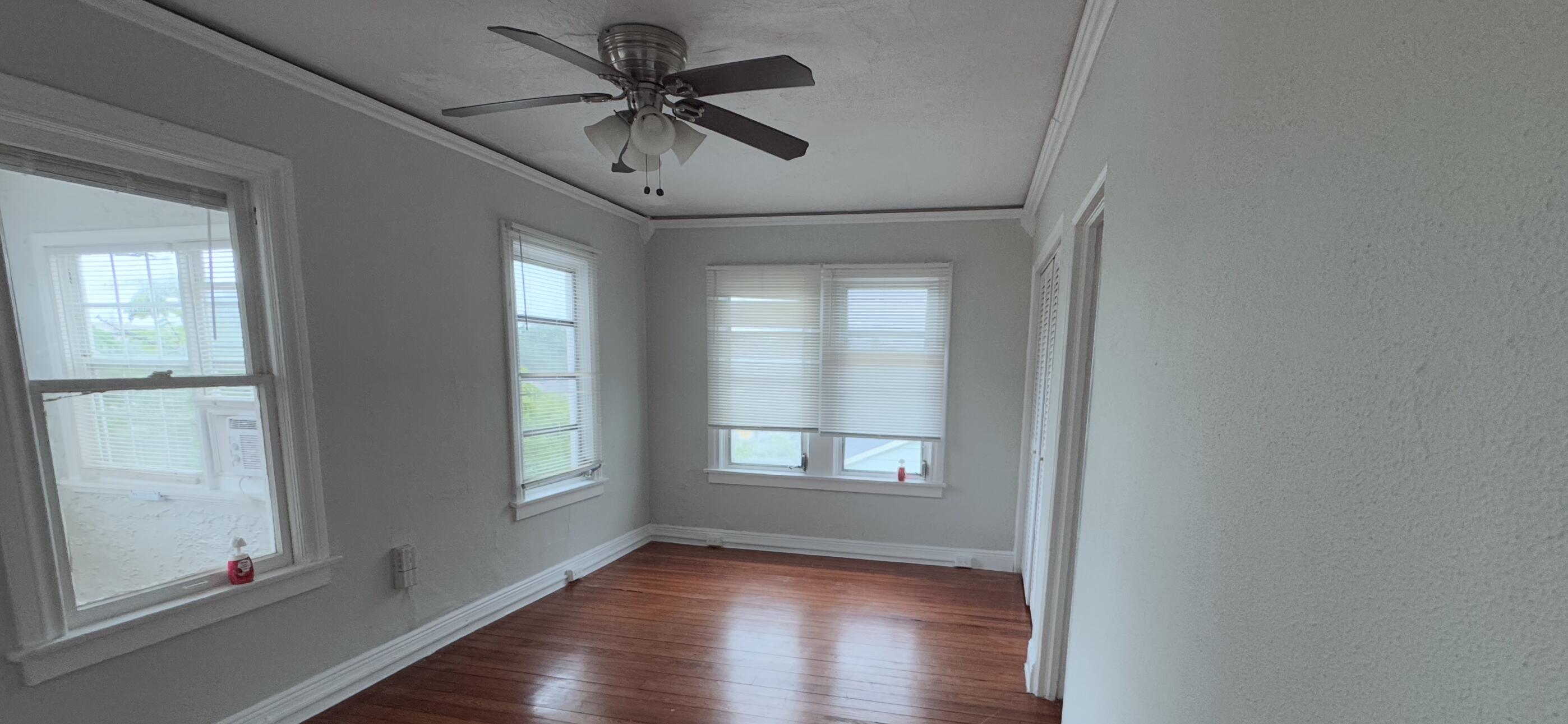 736 Omar Road, Unit 4 West Palm Beach, FL 33405 - Photo 9 of 17 a view of an empty room with a window and wooden floor