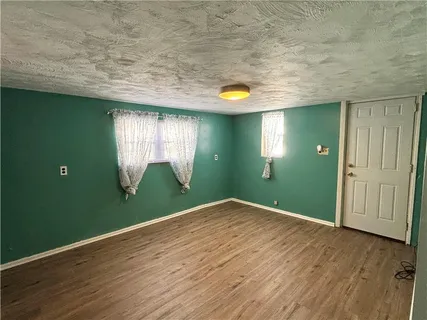a view of a hallway with wooden floor and stairs