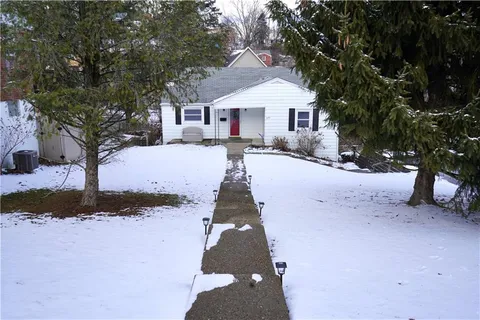 a front view of a house with a yard covered in snow