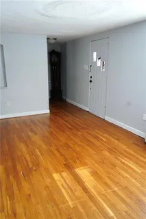 a view of empty room with wooden floor