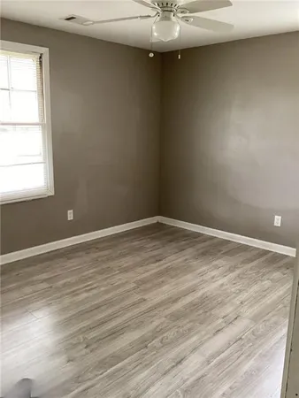 en empty room with wooden floor and window