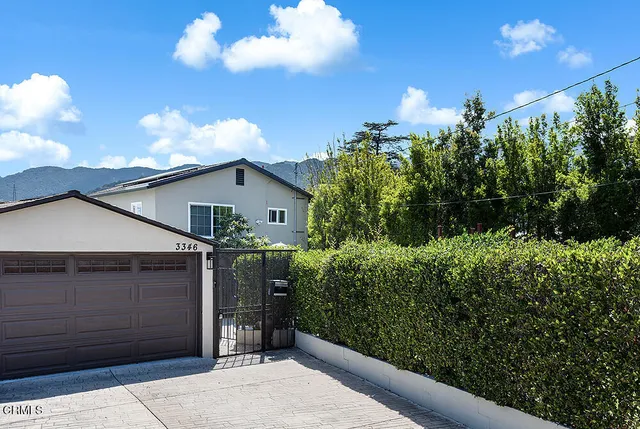 a view of a house with a backyard and garden
