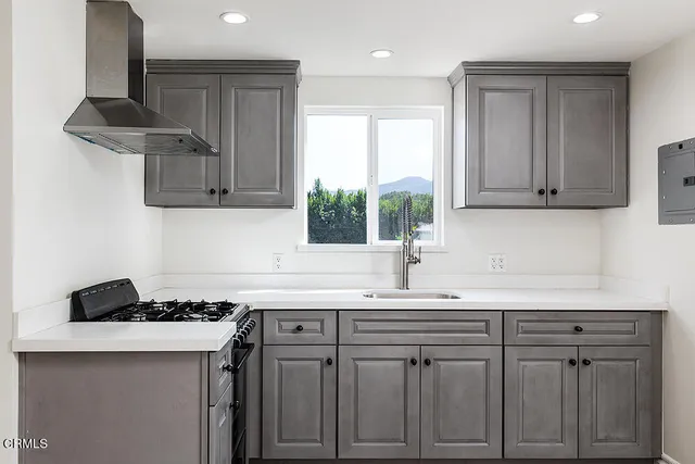 a kitchen with stainless steel appliances granite countertop a sink stove and cabinets