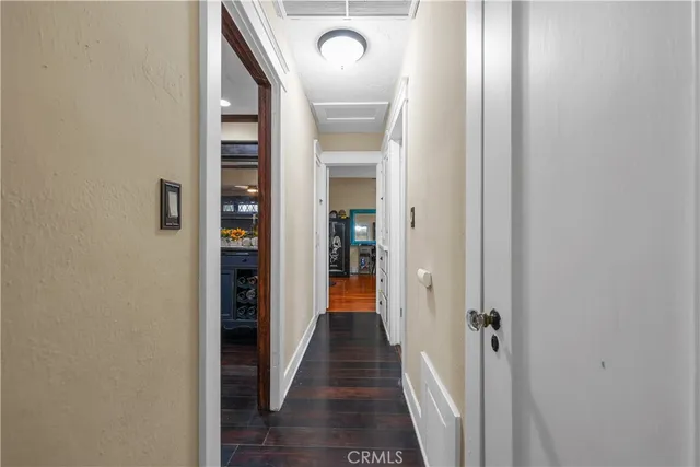 a view of a hallway with wooden floor and a door
