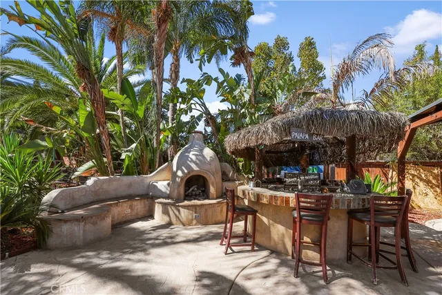 a view of a patio with table and chairs potted plants and large tree