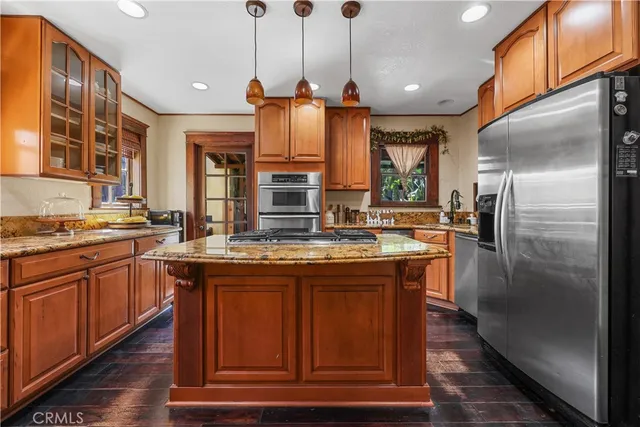 a kitchen with stainless steel appliances granite countertop a sink and a refrigerator
