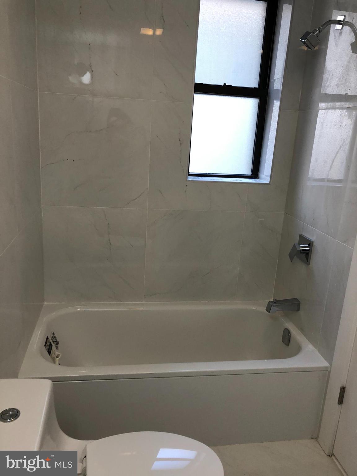 5101-7 North 12th Street, Unit 3C Philadelphia, PA 19141 - Photo 5 of 6 a bathroom with a bathtub and a window