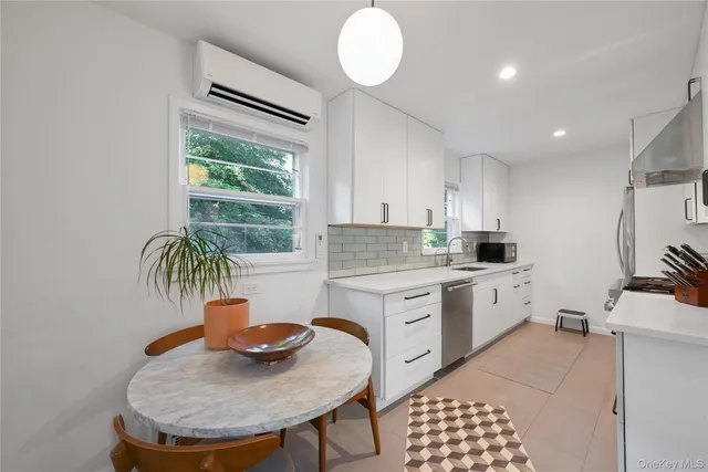 a kitchen with stainless steel appliances granite countertop a sink a stove a dining table and chairs