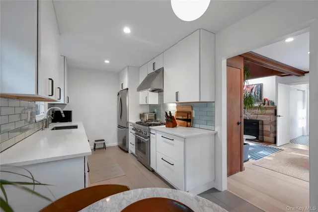 a kitchen with white cabinets and appliances