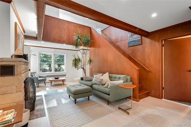 a living room with furniture a fireplace and a large window