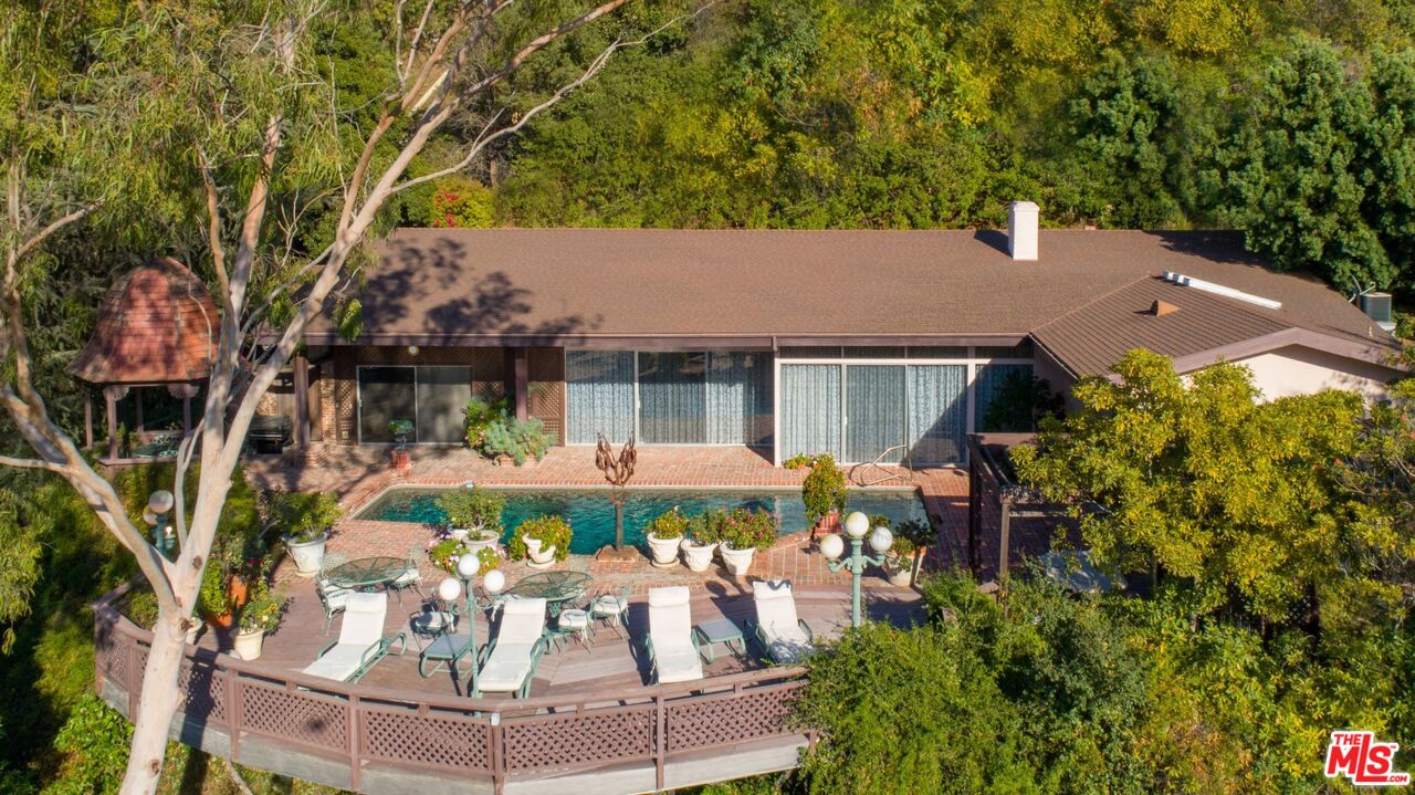 10895 Chalon Road Los Angeles, CA 90077 - Photo 12 of 19 front view of house with a yard and potted plants