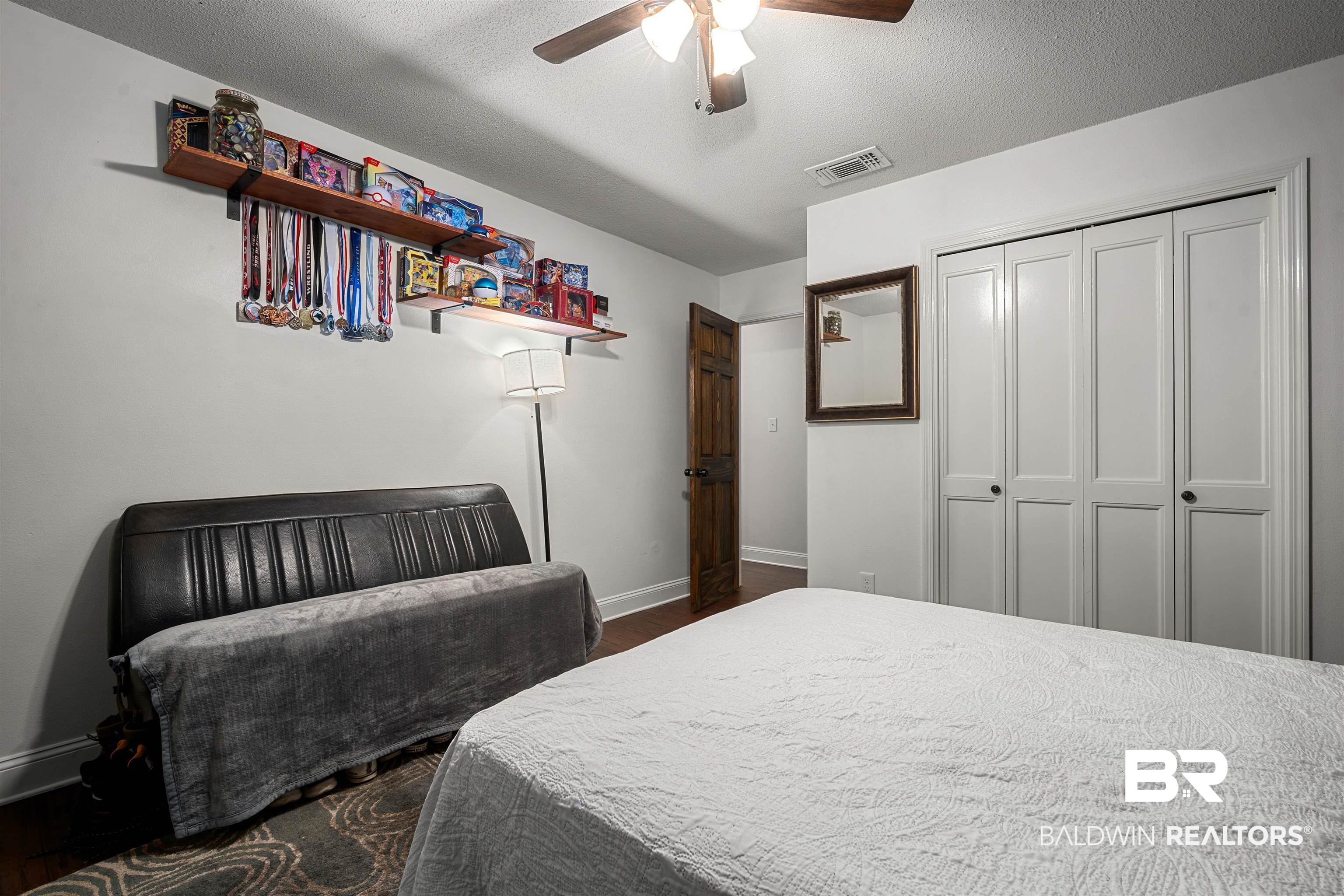 71 Caisson Trace Daphne, AL 36527 - Photo 21 of 36 Interior room with wood-finish flooring, white walls, and a ceiling fan with integrated lighting