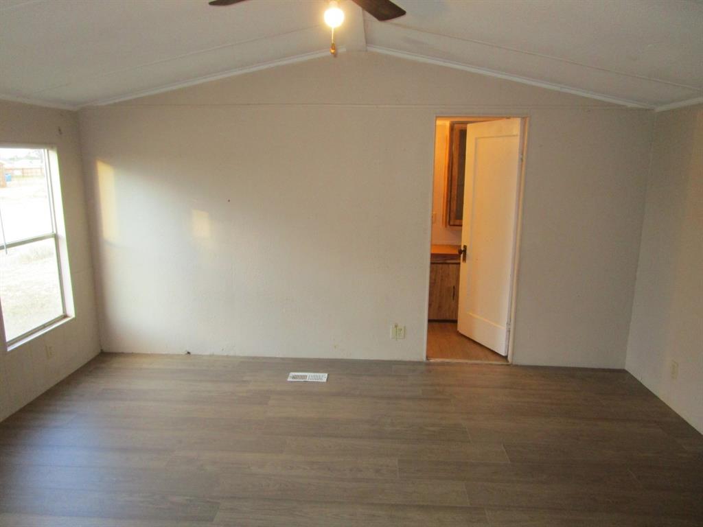800 Bluff Street Sweetwater, TX 79556 - Photo 17 of 19 an empty room with wooden floor and windows