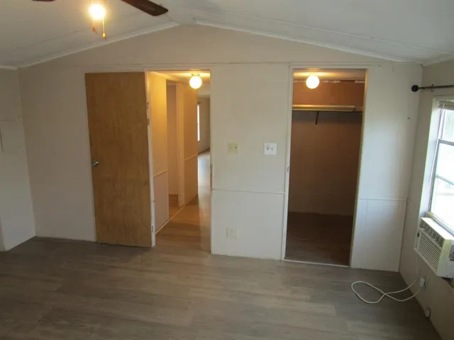 an empty room with windows and closet